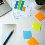 Workspace with laptop, graph, sticky notes, pen